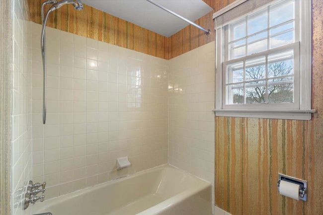Bathroom with wallpapered walls and bathtub / shower combination | Image 23