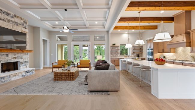 Living area featuring beam ceiling, light wood-style floors, a fireplace, a high ceiling, and a ceiling fan | Image 7