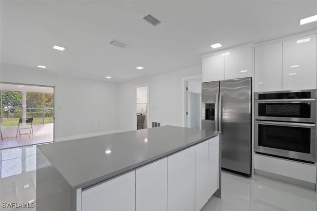 Kitchen featuring white cabinetry, modern cabinets, visible vents, and stainless steel appliances | Image 8