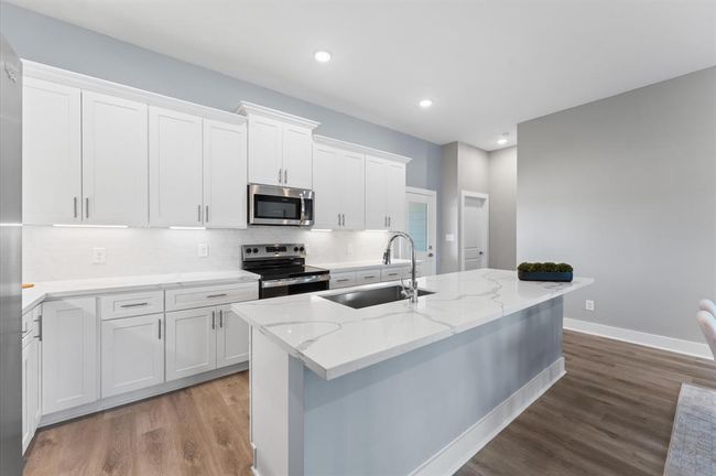 Stunning kitchen with quartz countertops, ample cabinetry, and stainless steel appliances included. | Image 15