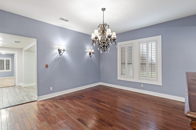 Unfurnished dining area featuring wood finished floors, a chandelier, and baseboards | Image 14