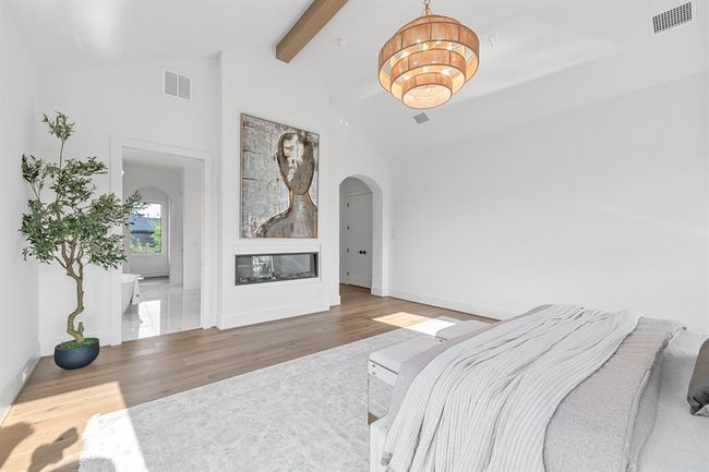 This serene primary suite features beautiful white oak hardwood floors that add warmth and elegance to the space. An abundance of natural light pours in through the windows, filling the room with a bright, airy ambiance that enhances the peaceful and inviting atmosphere. | Image 38