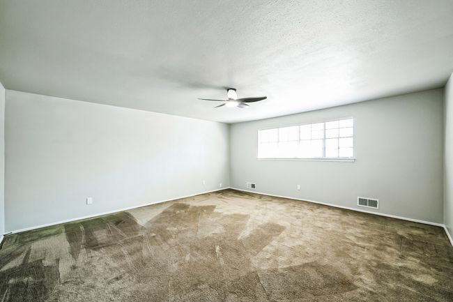 Empty room featuring visible vents, carpet flooring, a textured ceiling, and ceiling fan | Image 21