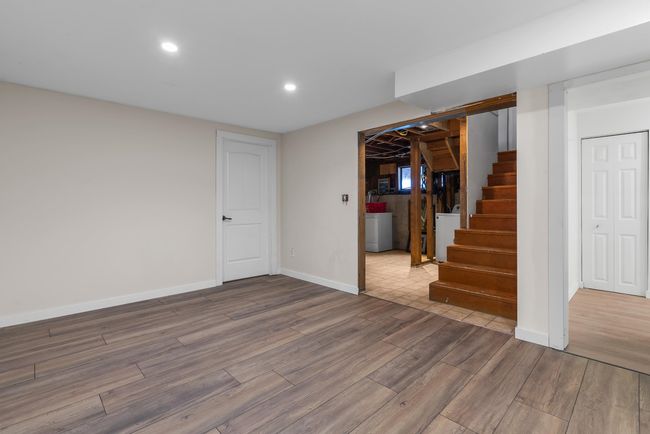 Finished below grade area featuring stairway, wood finished floors, baseboards, washer / dryer, and recessed lighting | Image 22