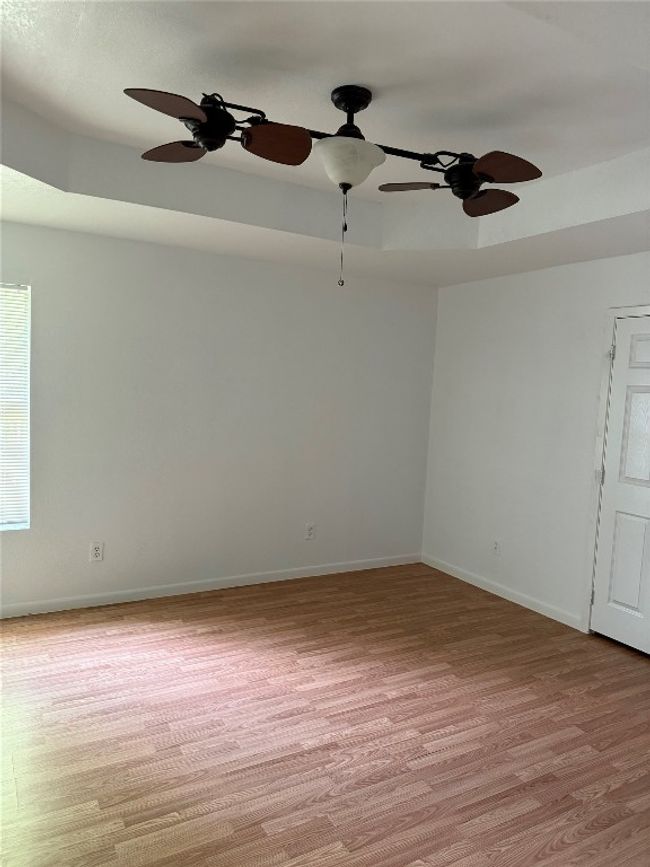 Empty room featuring light wood-type flooring and a ceiling fan | Image 7