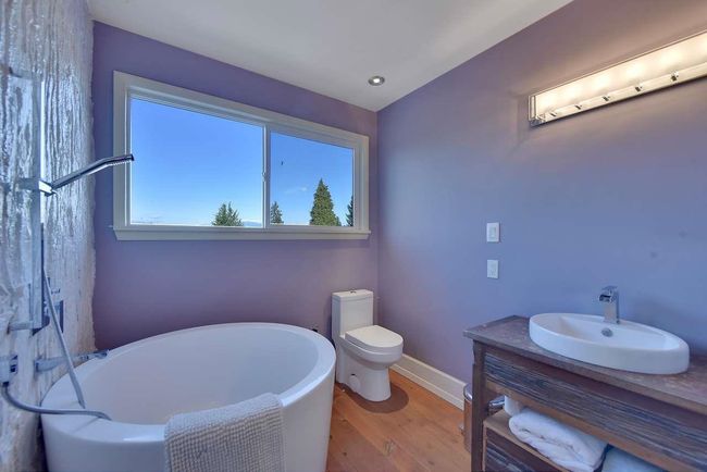Bathroom with a soaking tub, wood finished floors, vanity, and recessed lighting | Image 34