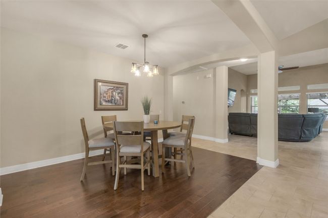 Kitchen featuring open floor plan, stainless steel appliances, ceiling fan, light stone counters, and decorative backsplash | Image 4