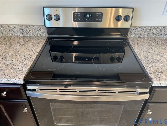 Kitchen view of light stone counters and electric range | Image 18
