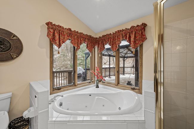 Primary bathroom complete with a view of the backyard and the deck! | Image 27