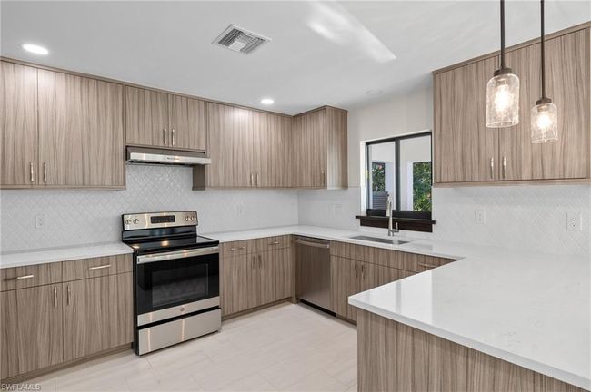 Kitchen featuring light tile patterned floors, stainless steel appliances, tasteful backsplash, and sink | Image 4
