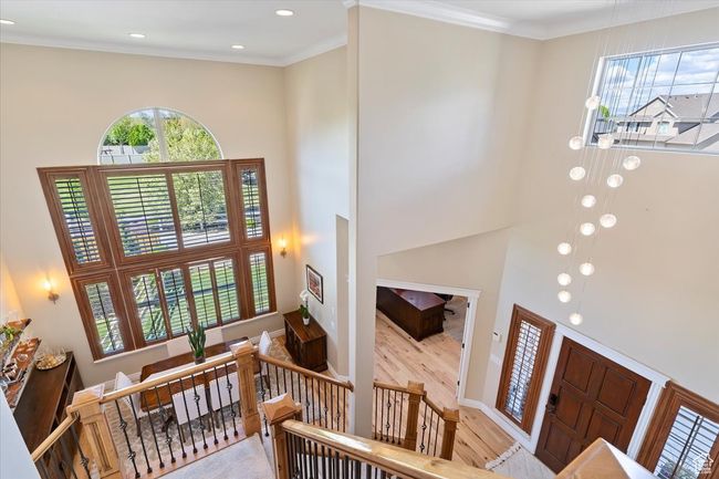 Entrance foyer featuring recessed lighting, crown molding, a towering ceiling, and wood finished floors | Image 6