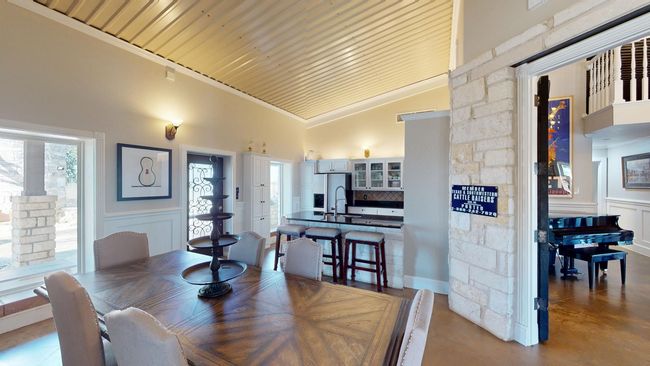 Dining room with high vaulted ceiling, a wealth of natural light, wainscoting, and crown molding | Image 12