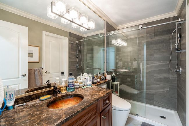 Bathroom with ornamental molding, vanity, a shower stall, toilet, and a chandelier | Image 24