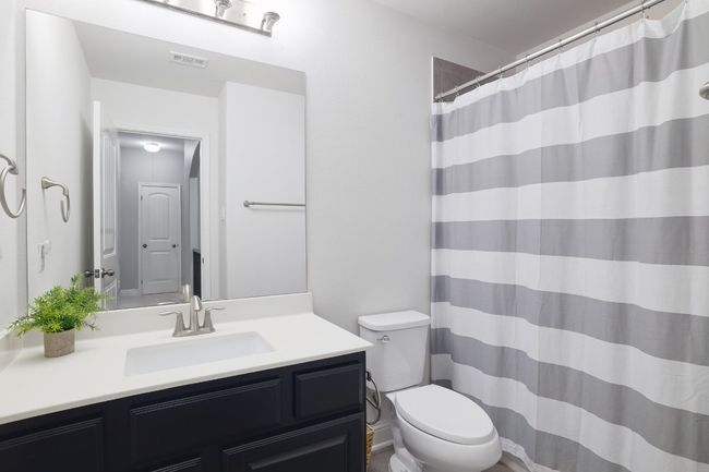 Bathroom with toilet, vanity, and a shower with curtain | Image 30