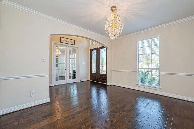 Elegant dining room featuring abundant natural light, and a stunning chandelier, perfect for entertaining and enjoying exquisite dinners with the family. | Image 8