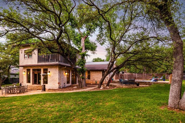 Rear view of house featuring the lawn, tire swing, fence, and second patio area | Image 13