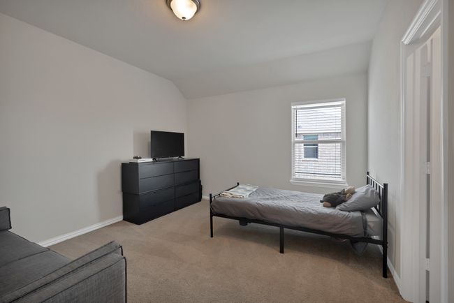 Bedroom featuring baseboards, vaulted ceiling, and light colored carpet | Image 28