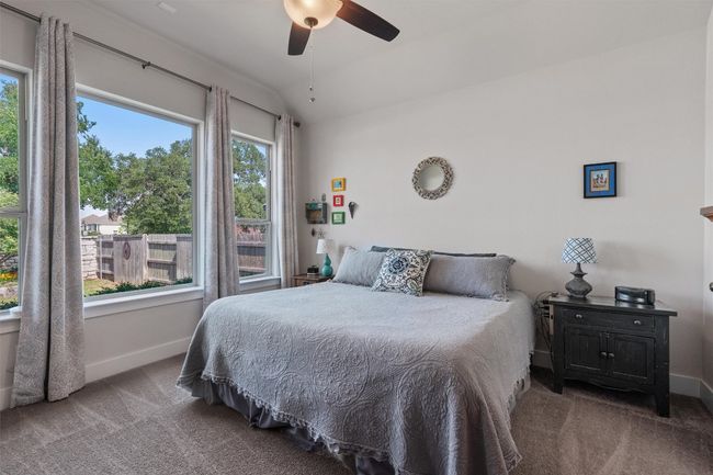 Bedroom with carpet flooring, baseboards, ceiling fan, and lofted ceiling | Image 14