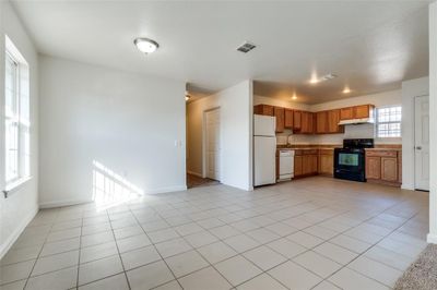 Kitchen with sink, light tile patterned floors, and white appliances | Image 2