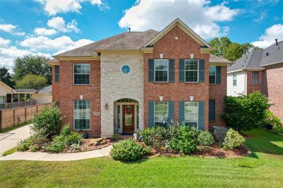 The lush landscaping and stone-accented brick exterior make for great curb appeal | Image 3