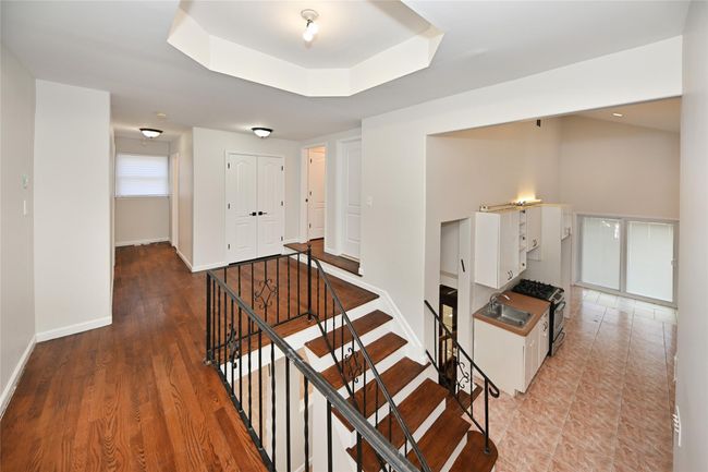 Staircase featuring baseboards and a tray ceiling | Image 15