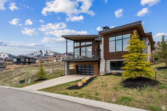 Contemporary home with a balcony, concrete driveway, an attached garage, a mountain view, and a front yard | Image 67