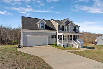 View of front of home featuring a garage, a front lawn, and covered porch | Image 2