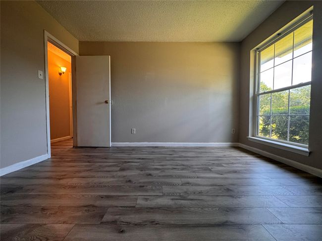 Spare room featuring wood finished floors and a textured ceiling | Image 14