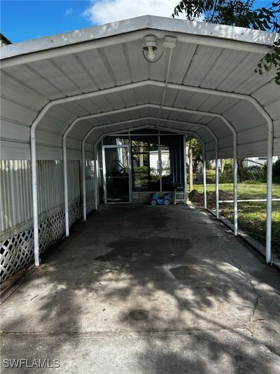 View of parking / parking lot featuring a carport | Image 1