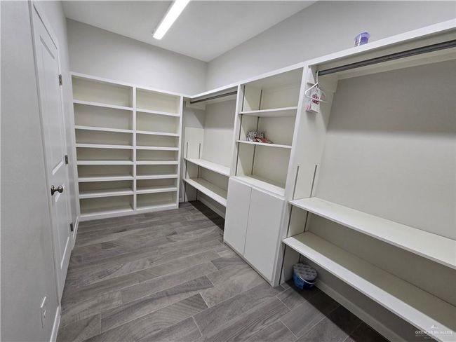 Spacious closet featuring dark wood-style flooring | Image 11