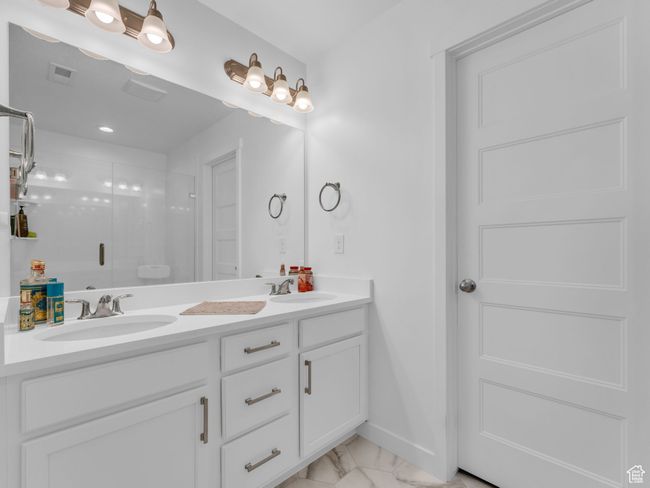 Owners Suite - Bathroom featuring marble look tiles, double vanity, and a stall shower | Image 29