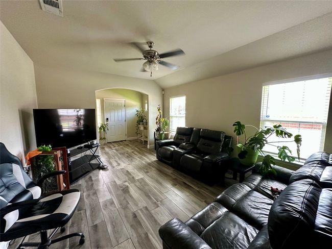 Living area with arched walkways, ceiling fan, and wood finished floors | Image 11