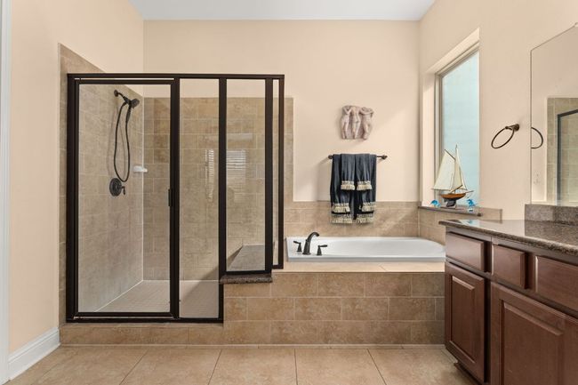 Bathroom with vanity, tile patterned floors, a stall shower, and a bath | Image 13