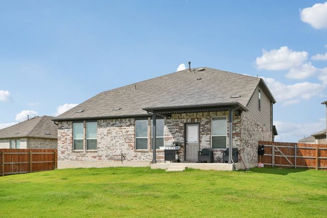 Back of property featuring a fenced backyard, brick siding, and a patio | Image 31