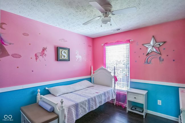 bedroom with a textured ceiling, hardwood / wood-style floors, and ceiling fan | Image 26