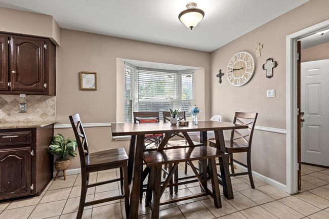 Dining space with light tile patterned floors and baseboards | Image 8