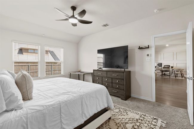 Carpeted bedroom featuring lofted ceiling, visible vents, a ceiling fan, and baseboards | Image 17