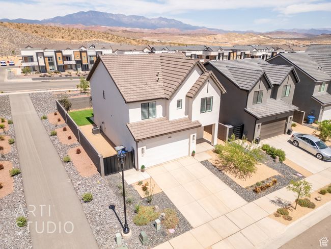 View of front of home with stucco siding, a tiled roof, a residential view, and a garage | Image 41