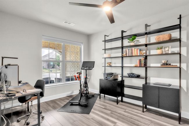 Home office featuring visible vents, a ceiling fan, baseboards, and wood finished floors | Image 11