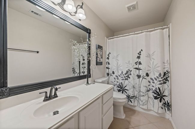 Bathroom with tile patterned floors, vanity, toilet, and visible vents | Image 30