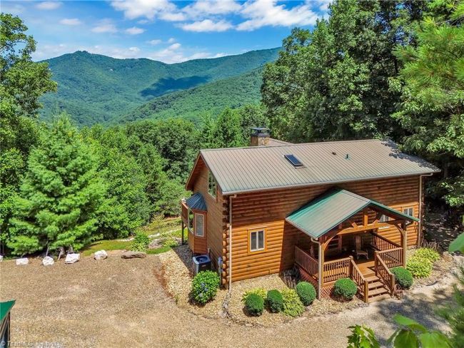 Nestled in nature, this rustic cabin boasts a huge deck offering panoramic, long-range mountain views, perfect for embracing the tranquility of the outdoors. | Image 5