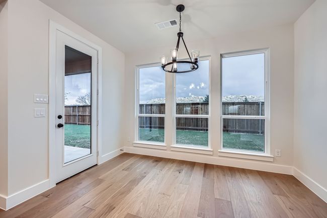 Unfurnished dining area featuring light wood-type flooring, baseboards, a chandelier, and visible vents | Image 11