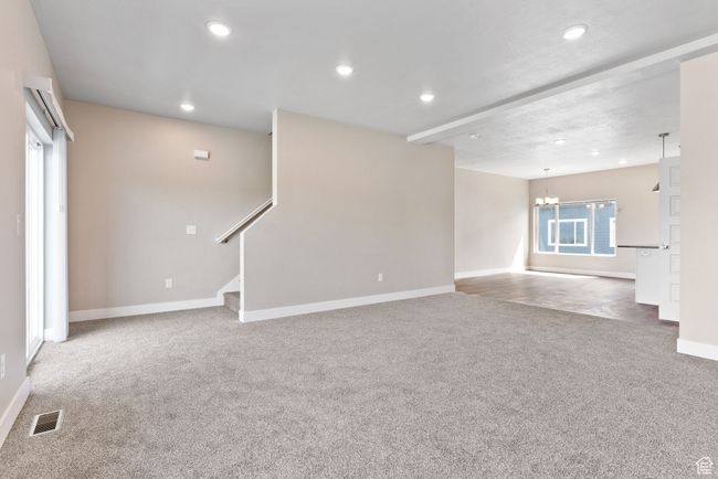 Unfurnished living room with recessed lighting, baseboards, carpet floors, visible vents, and a notable chandelier | Image 5