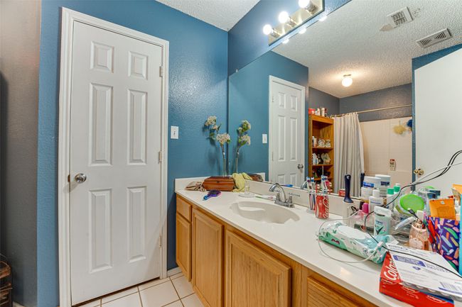 Full bath with a shower with shower curtain, a textured ceiling, visible vents, and tile patterned flooring | Image 9