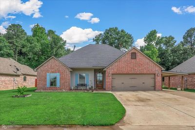 View of property with a garage and a front lawn | Image 1