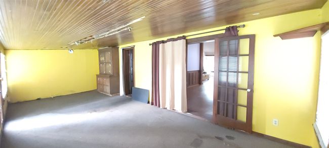 Carpeted spare room featuring wooden ceiling | Image 11