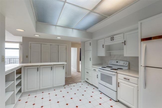 Kitchen with white appliances, light flooring, light countertops, recessed lighting, and white cabinets | Image 4