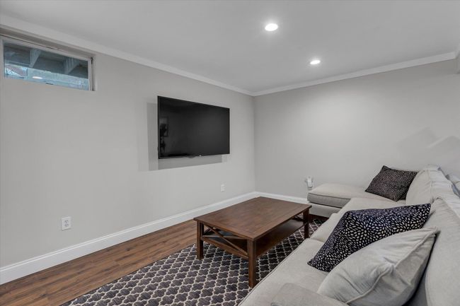 Lower level living area featuring recessed lighting, ornamental molding, baseboards, and wood finished floors | Image 10