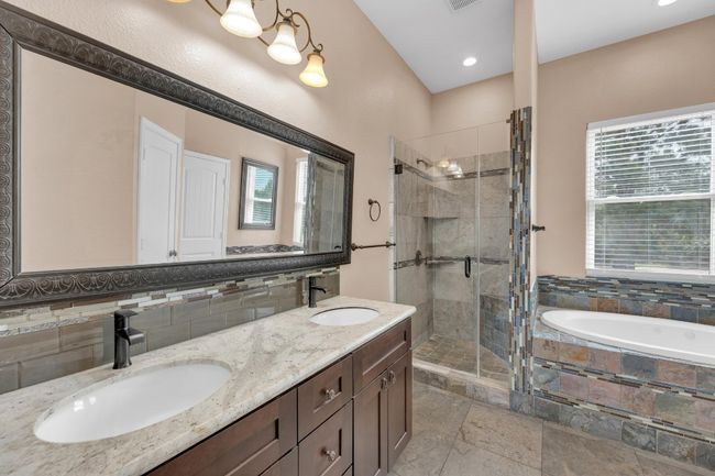 Full bath featuring a shower stall, a garden tub, double vanity, and recessed lighting | Image 19