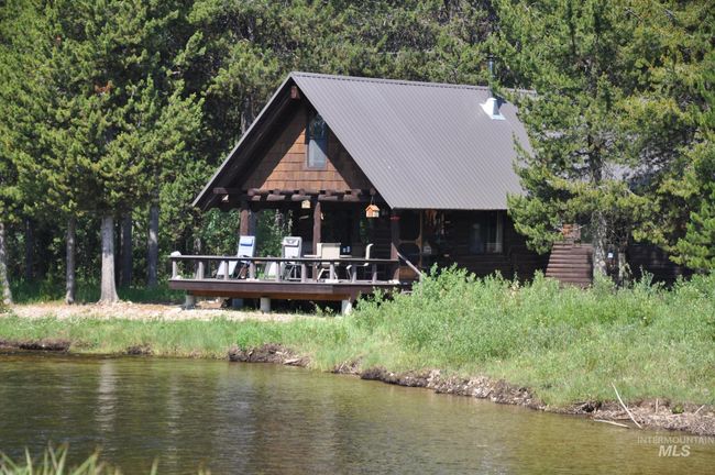 Rear view of house featuring a metal roof and a deck with water view | Image 5